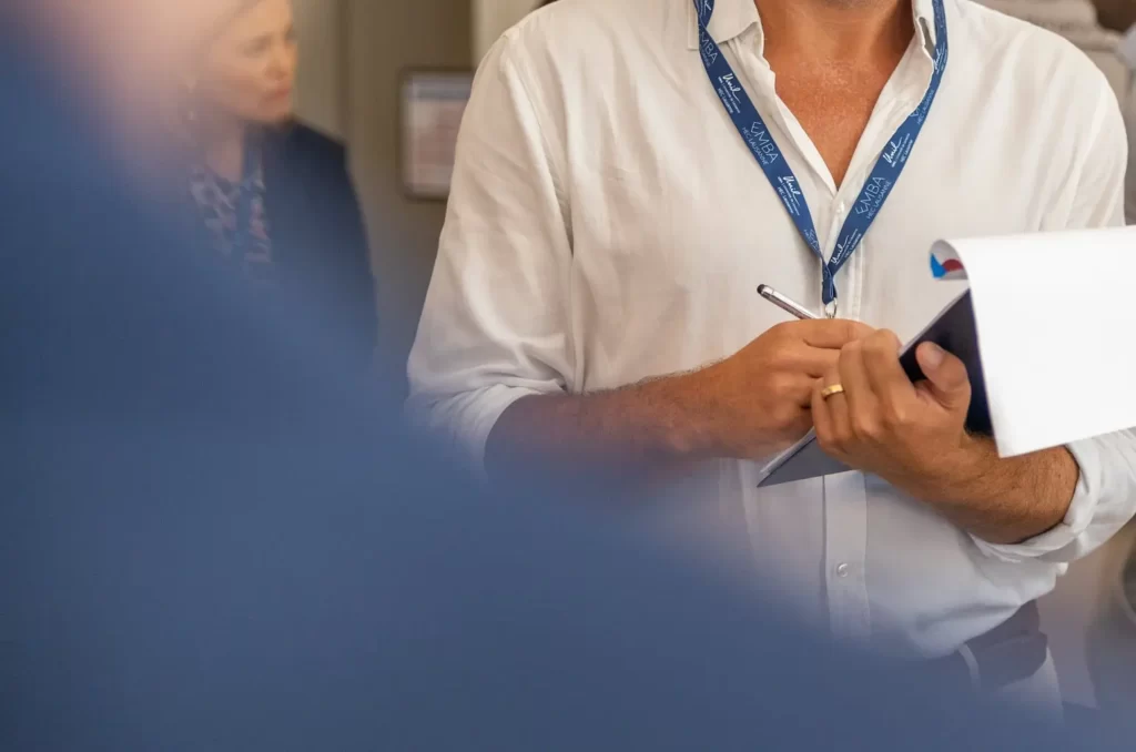 One person holding an HEC Lausanne EMBA Brochure